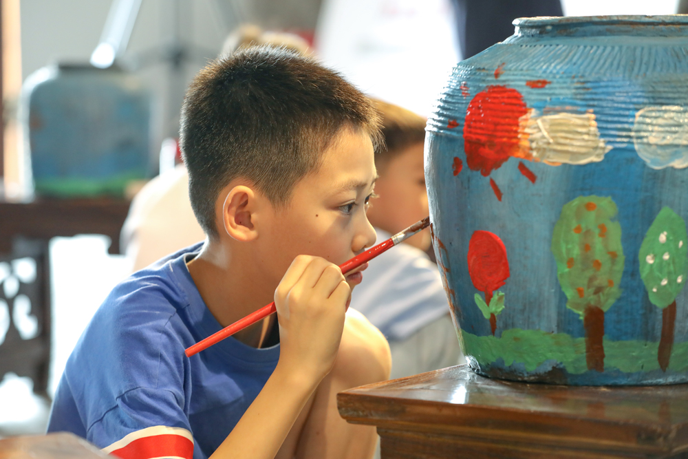 小朋友對廢棄瓦罐進行藝術創造。白羽攝