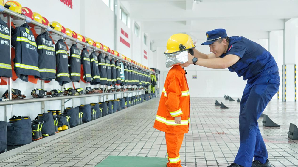 孩子們穿上消防員滅火防護服。姚遙攝