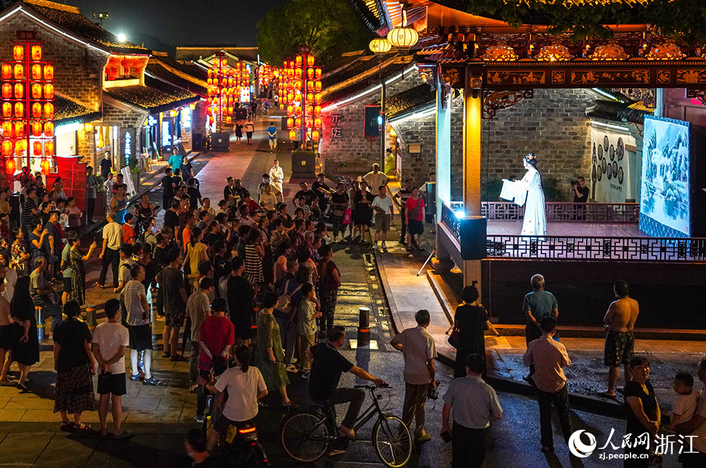 寧波市江北區慈城古縣城民權路上，游客在戲臺邊欣賞古風演藝。人民網 章勇濤攝