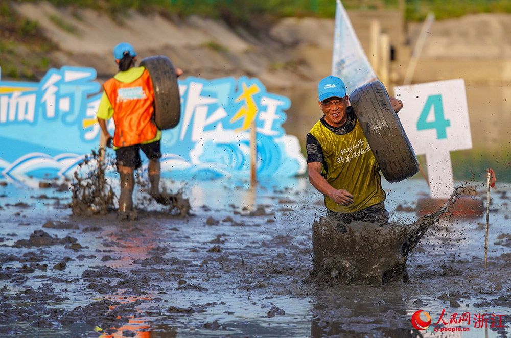 參賽選手在灘涂上進行灘涂搬物項目的比賽。人民網 章勇濤攝