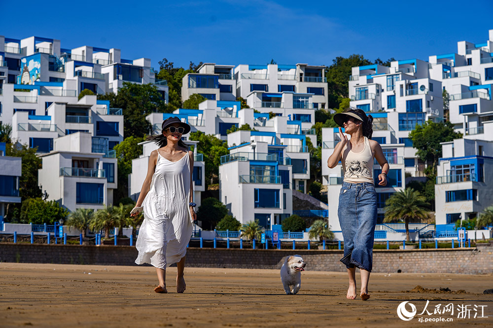 在舟山市岱山縣秀山島，游客盡情地踏浪戲水，欣賞美景。人民網 章勇濤攝