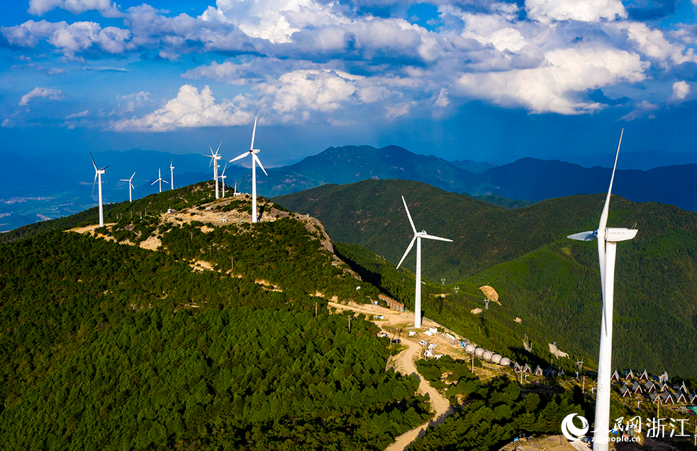 一臺臺發電機矗立在群山之中，蔚為壯觀，成為一道亮麗的風景線。人民網 章勇濤攝