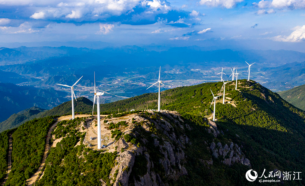 一臺臺發電機矗立在群山之中，蔚為壯觀，成為一道亮麗的風景線。人民網 章勇濤攝