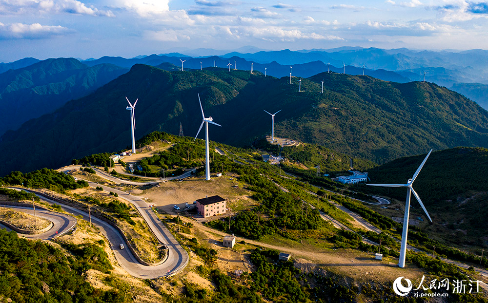 一臺臺發電機矗立在群山之中，蔚為壯觀，成為一道亮麗的風景線。人民網 章勇濤攝