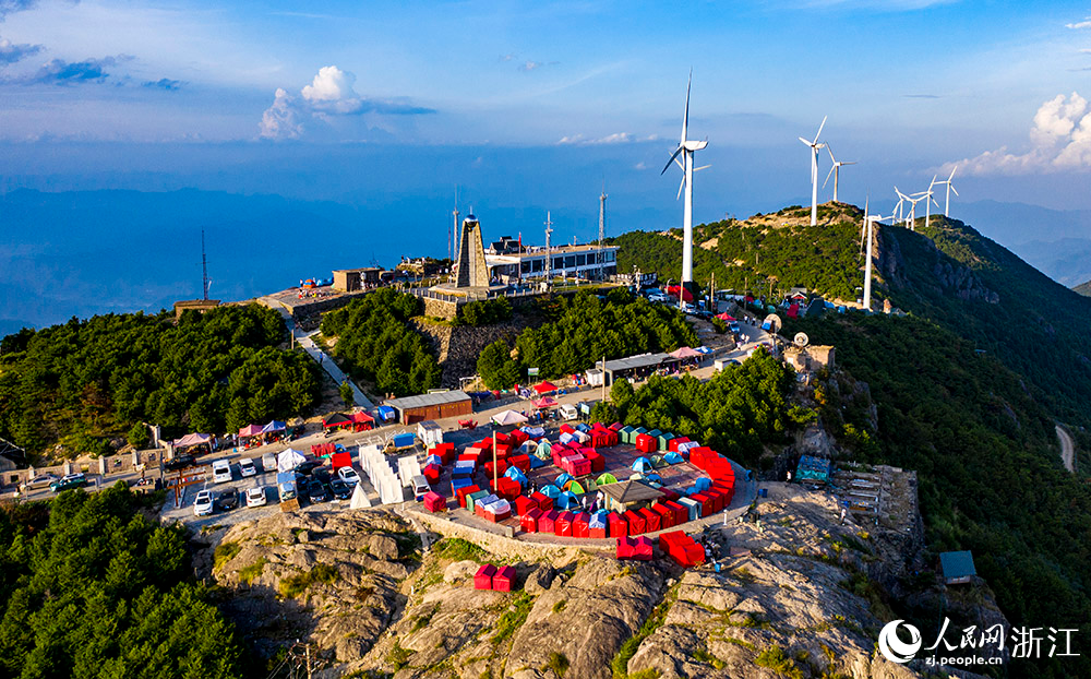 一臺臺發電機矗立在群山之中，蔚為壯觀，成為一道亮麗的風景線。人民網 章勇濤攝