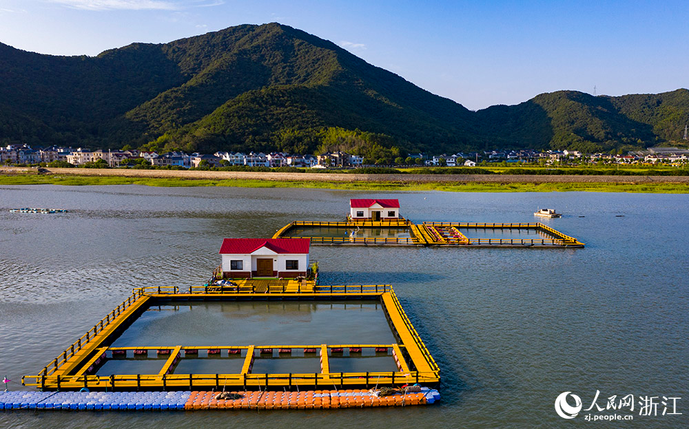 一方方橙黃色的養殖設施有序排列在蔚藍的海面上，成為斑斕海岸線一道亮麗的風景。人民網 章勇濤攝