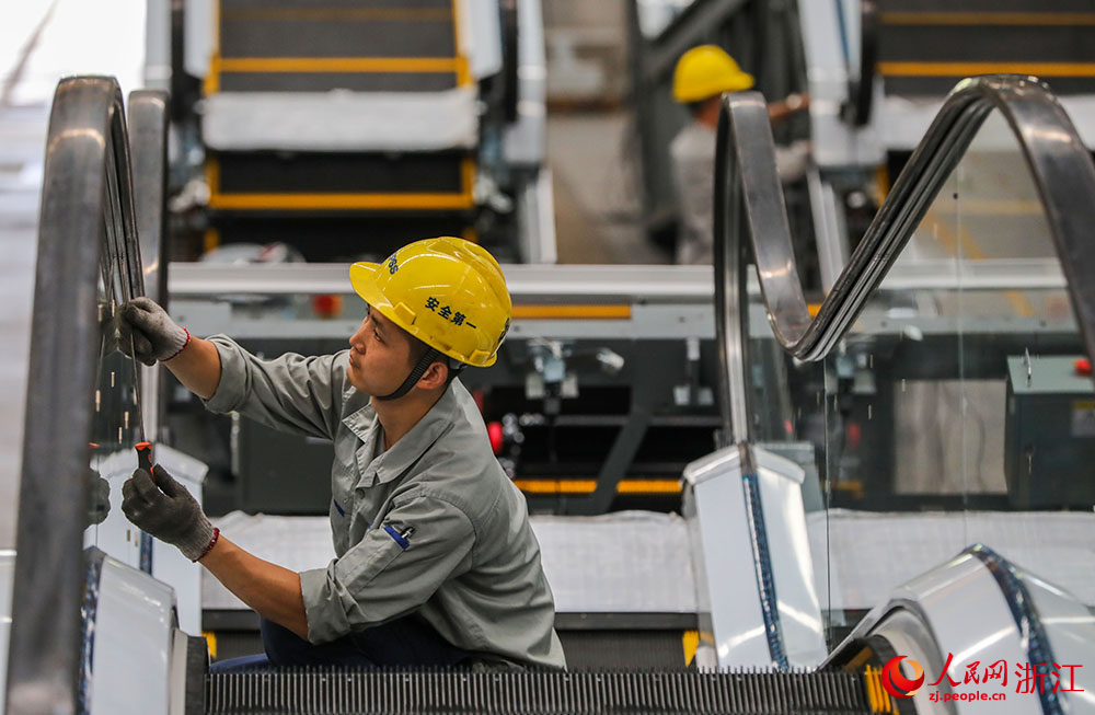 近日，在湖州市南潯區一電梯企業，工作人員在對扶梯進行組裝調整。人民網 章勇濤攝