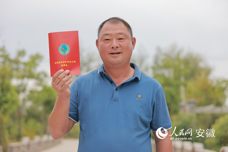 一位種糧大戶興奮地展示自己簽訂的承包土地地票證。人民網 王曉飛攝