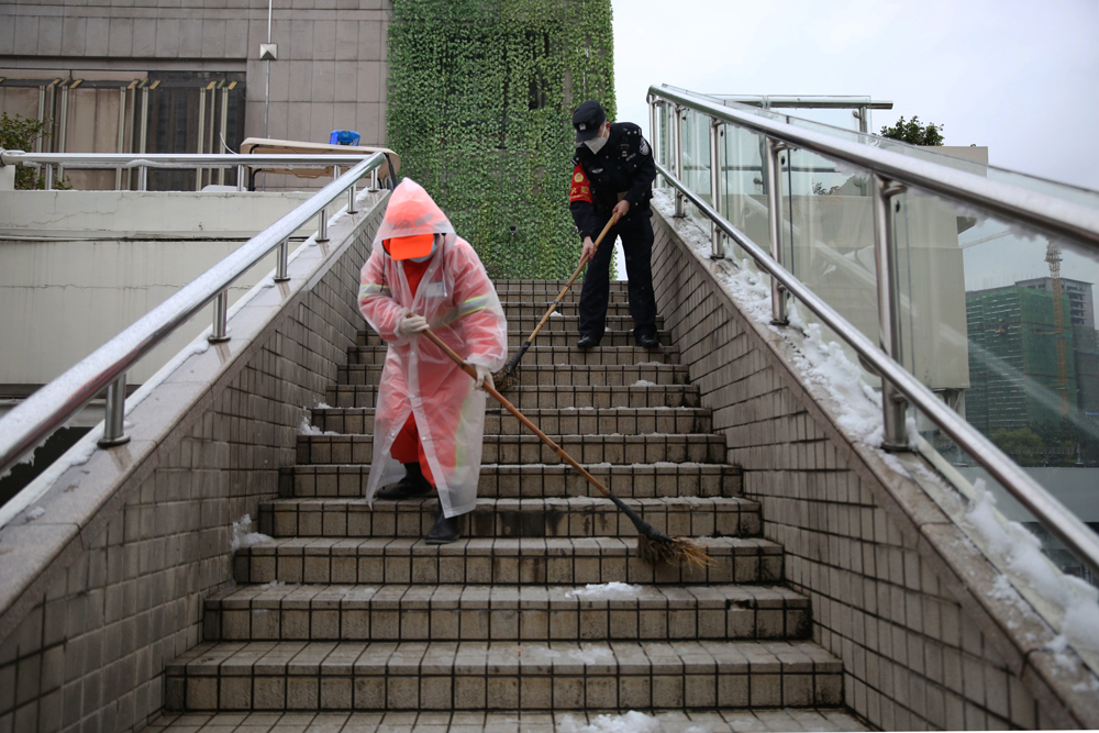 杭州站派出所民警會同車站保潔員清掃積雪。陳清攝