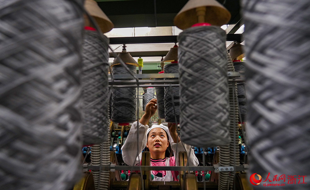 工人在車間紡織作業，一片忙碌。人民網 章勇濤攝