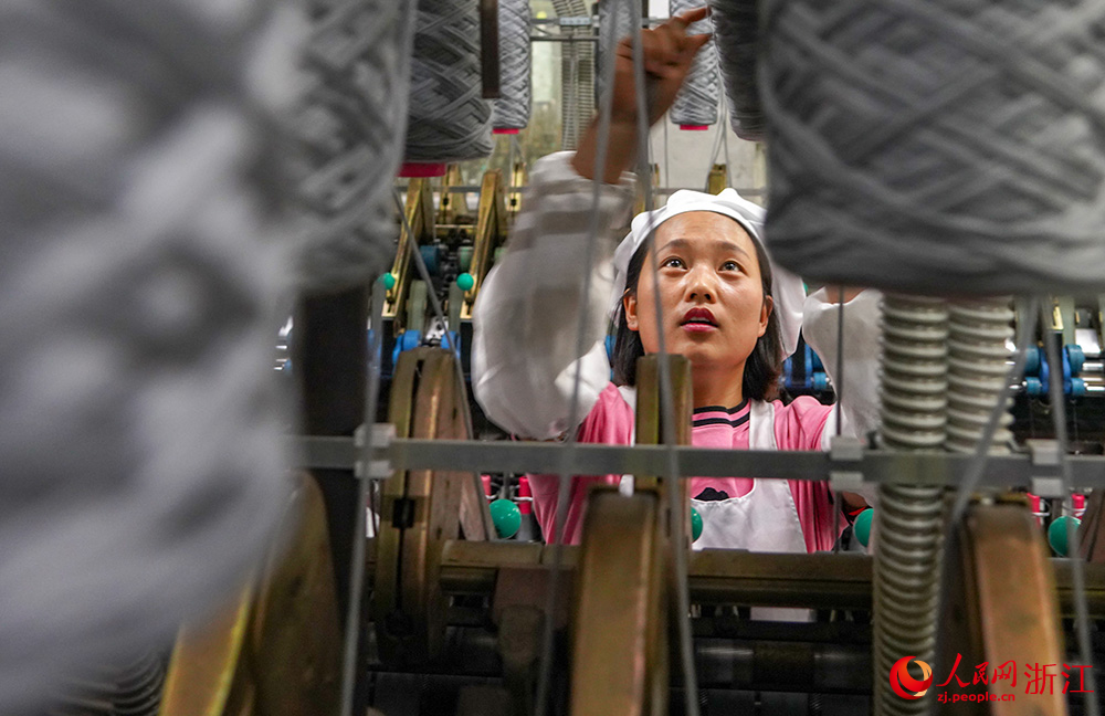工人在車間紡織作業，一片忙碌。人民網 章勇濤攝