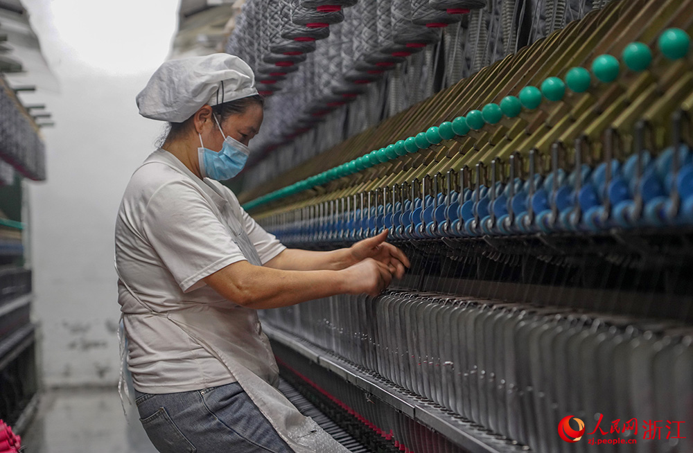 工人在車間紡織作業，一片忙碌。人民網 章勇濤攝