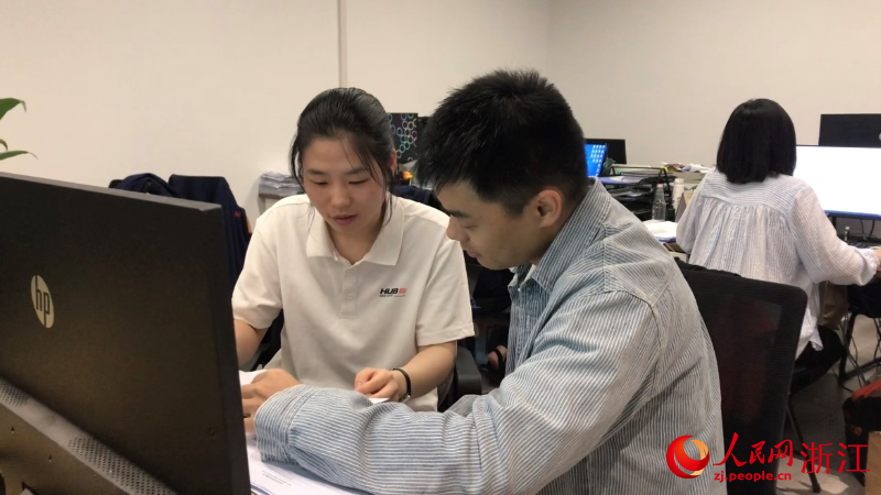 林松松（左）和同事討論下階段工作重點。人民網 秦銘澤攝