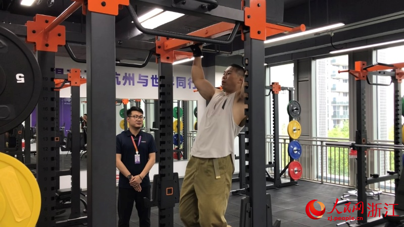 朱哲恒（左）為運動者做健身保障。人民網 秦銘澤攝