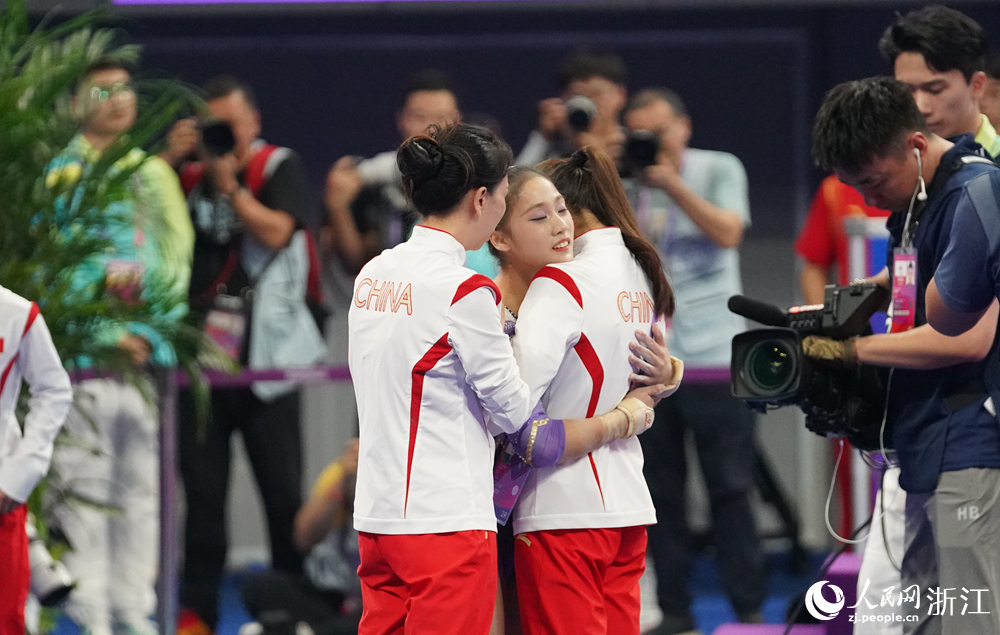 比賽結束后左彤與教練及隊友深情擁抱。人民網 陳陸洵攝