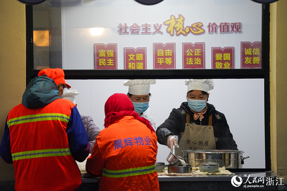 在浙江省慈溪市觀海衛鎮，環衛工人領取愛心早餐。人民網 章勇濤攝