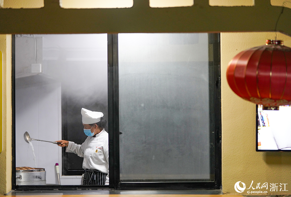 在浙江省慈溪市觀海衛鎮，滿屋蒸汽繚繞，工作人員在熬粥。人民網 章勇濤攝