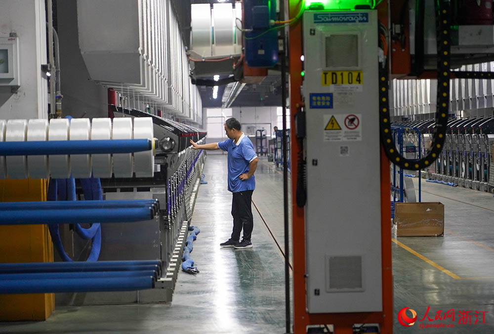 在浙江省紹興市柯橋區的一家化纖企業，工人在生產線上作業。人民網 章勇濤攝