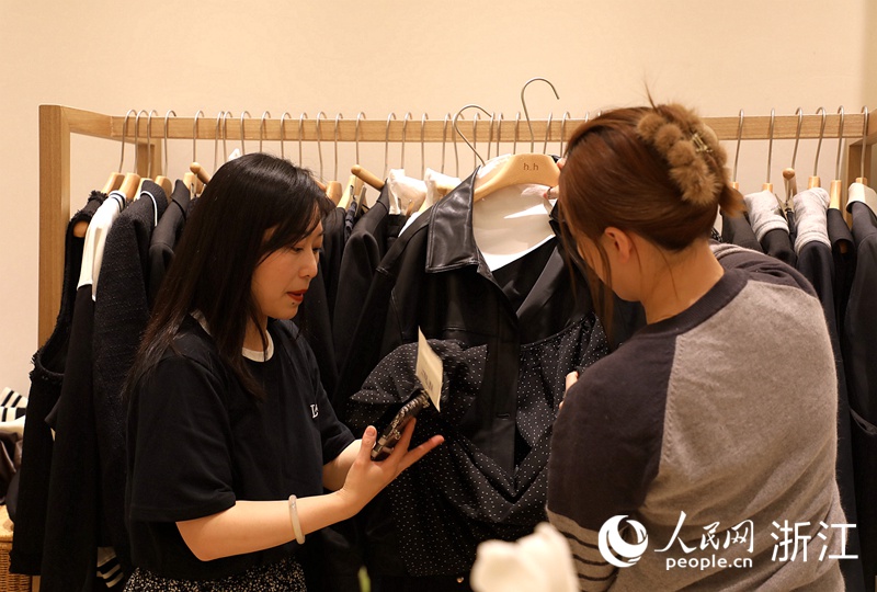 女裝店銷售人員正幫著客戶一起做春裝搭配。人民網 方彭依夢攝