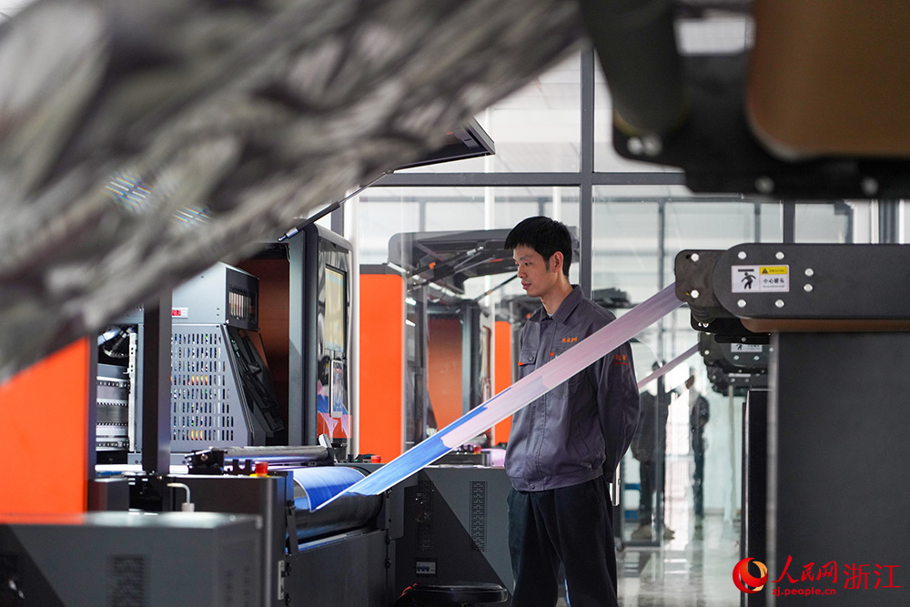 在浙江省紹興市柯橋區的印染企業，工人在數碼印花產線上趕制訂單。人民網 章勇濤攝