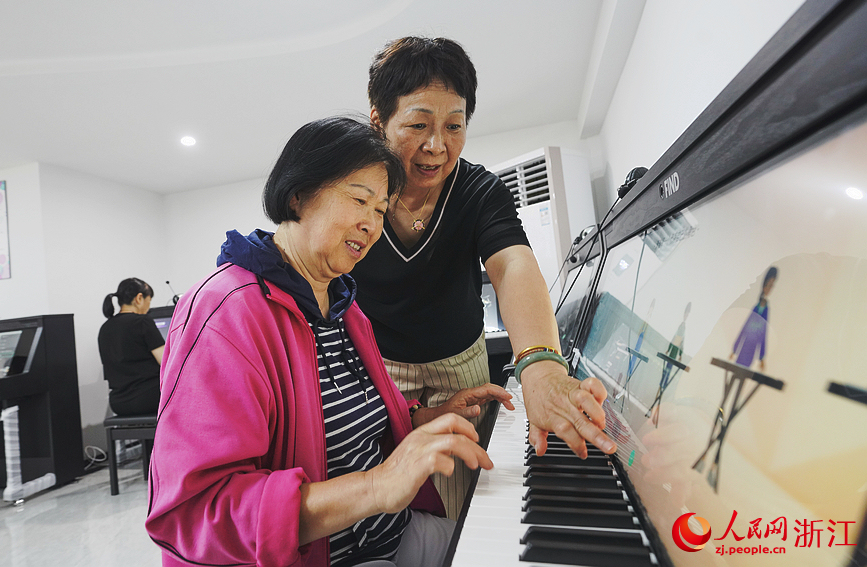 杭州翠苑街道九蓮社區居民活動室里傳出陣陣鋼琴聲，這里，一節自主鋼琴課正在火熱地進行。人民網 郭揚攝