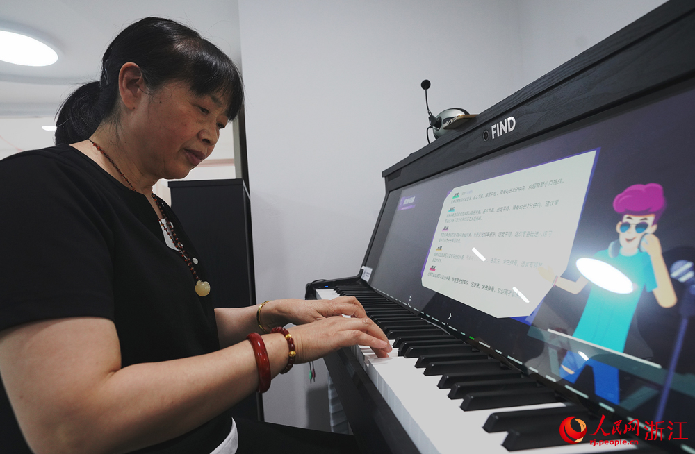 杭州翠苑街道九蓮社區居民活動室里傳出陣陣鋼琴聲，這里，一節自主鋼琴課正在火熱地進行。人民網 郭揚攝