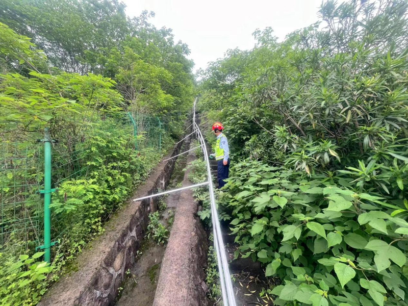 網格員在高速公路邊開展檢查。蔣才攝