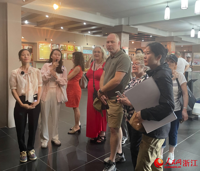 講解員梁銀娣（左一）正在講述舟山漁民營救“里斯本丸”號船英軍戰俘的故事。人民網記者 王麗瑋攝