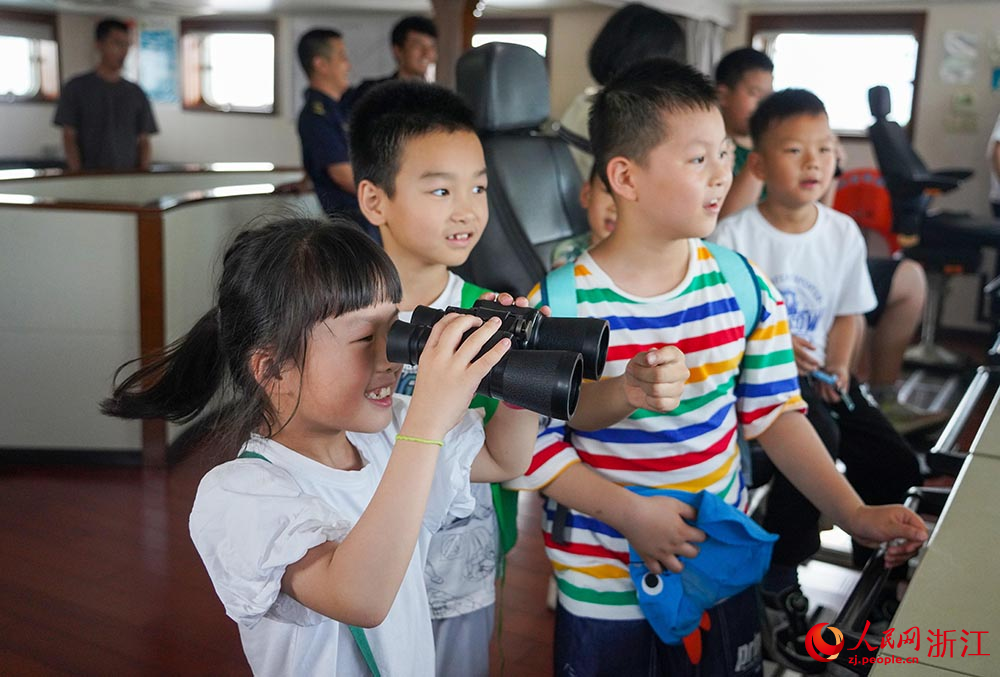 7月11日，“小候鳥”在寧波航標處“海巡163”輪上用望遠鏡尋找航標。人民網 章勇濤攝