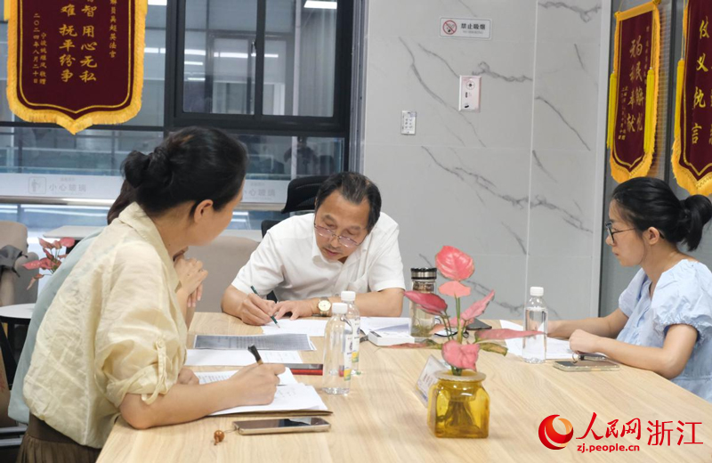 吳超英正在進行勞資糾紛調解。人民網 程欣攝