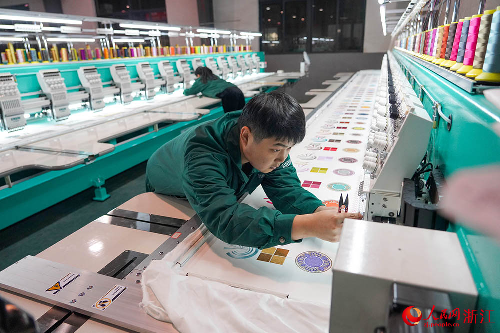 在浙江省諸暨市一家電腦刺繡機生產企業車間內，技術人員正忙著裝配、調試刺繡機。人民網 章勇濤攝