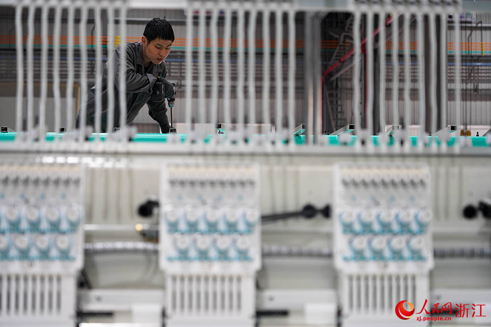 在浙江省諸暨市一家電腦刺繡機生產企業車間內，技術人員正忙著裝配、調試刺繡機。人民網 章勇濤攝