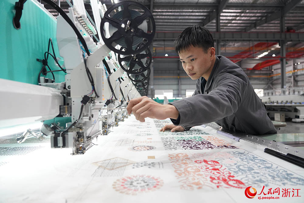 在浙江省諸暨市一家電腦刺繡機生產企業車間內，技術人員正忙著裝配、調試刺繡機。人民網 章勇濤攝