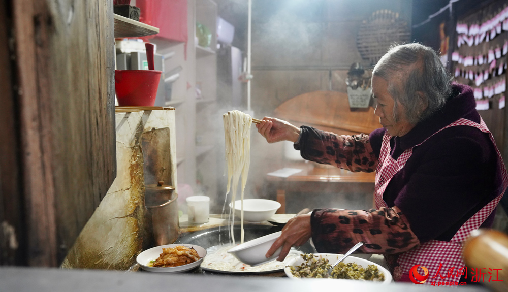劉素濃正在為游客煮面。人民網記者 郭揚攝