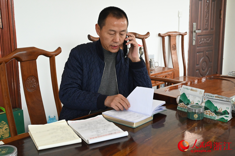 毛金君和他記滿了香榧訂單的本子。人民網記者 葉賓得攝