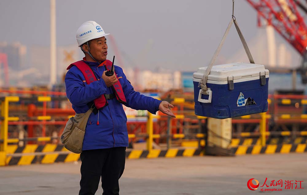杭州灣跨海鐵路大橋施工現場，周朋接收通過無人機運送過來的工程物資。人民網 章勇濤攝