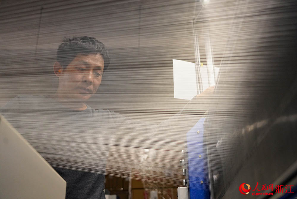 在浙江省紹興市柯橋區一家紡織企業，工人在生產線上趕制訂單。人民網 章勇濤攝