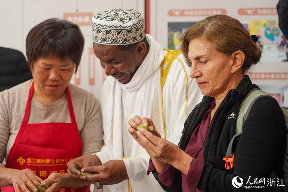 浙江省義烏市江東街道雞鳴山社區中外居民共同制作清明果。人民網 章勇濤攝