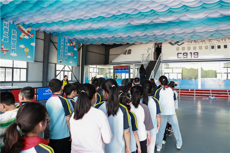 孩子們排隊登上C919國產大飛機模擬機艙。人民網記者 張俊攝