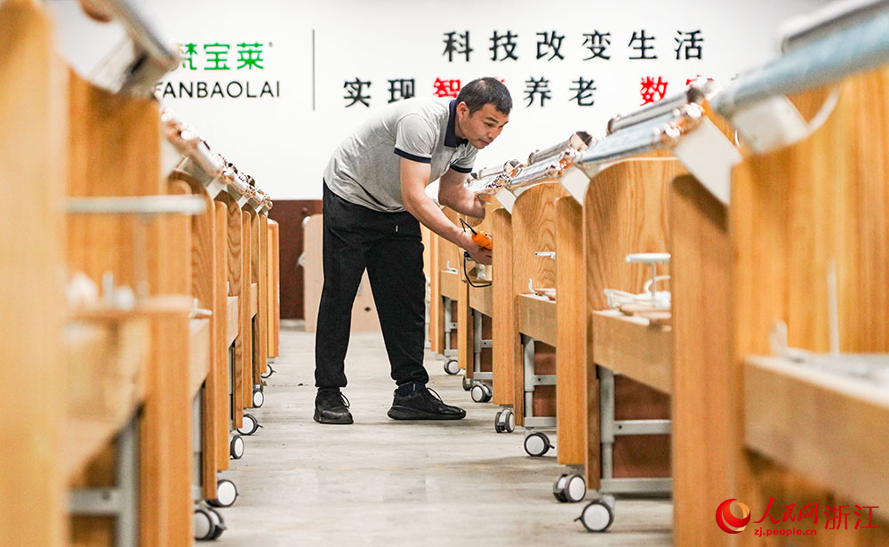 在寧波前灣新區一家企業，工人在趕制智能護理床的訂單。人民網 章勇濤攝