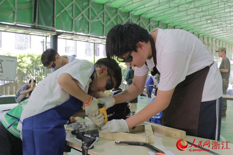 小隊長馬伏遠正在和同學們一起搭建電影《哪吒》里的建筑。人民網記者 王麗瑋攝
