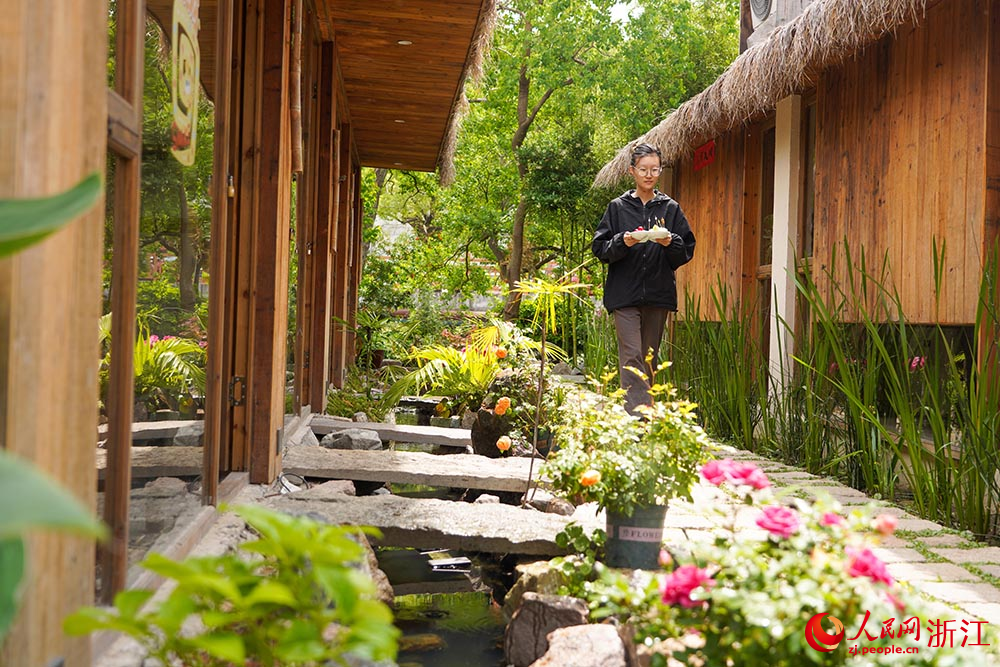 在浙江省慈溪市滸山街道大河口藝術部落，茶藝師在給客人送果盤。人民網 章勇濤攝
