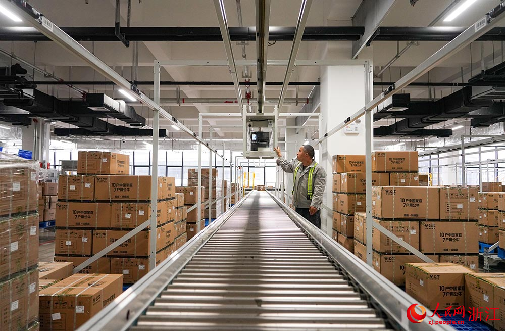 在浙江省慈溪市觀海衛鎮一家電企業，工人根據電子標簽亮燈提示正在揀貨。人民網 章勇濤攝