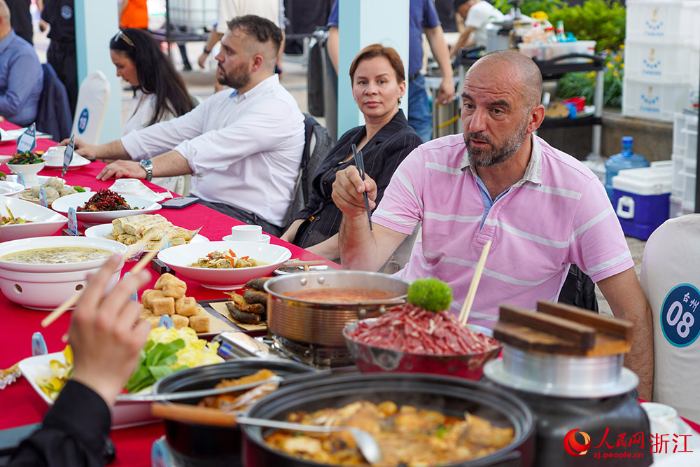 5月21日，國際友人在寧波老外灘學習使用筷子就餐。人民網 章勇濤攝