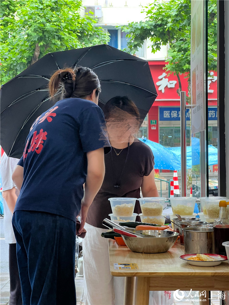 為了多賺錢，從下午4點到徹底天黑前的空檔，徐姐還在店門口支起了賣冷面的小桌。人民網記者 沐一帆攝