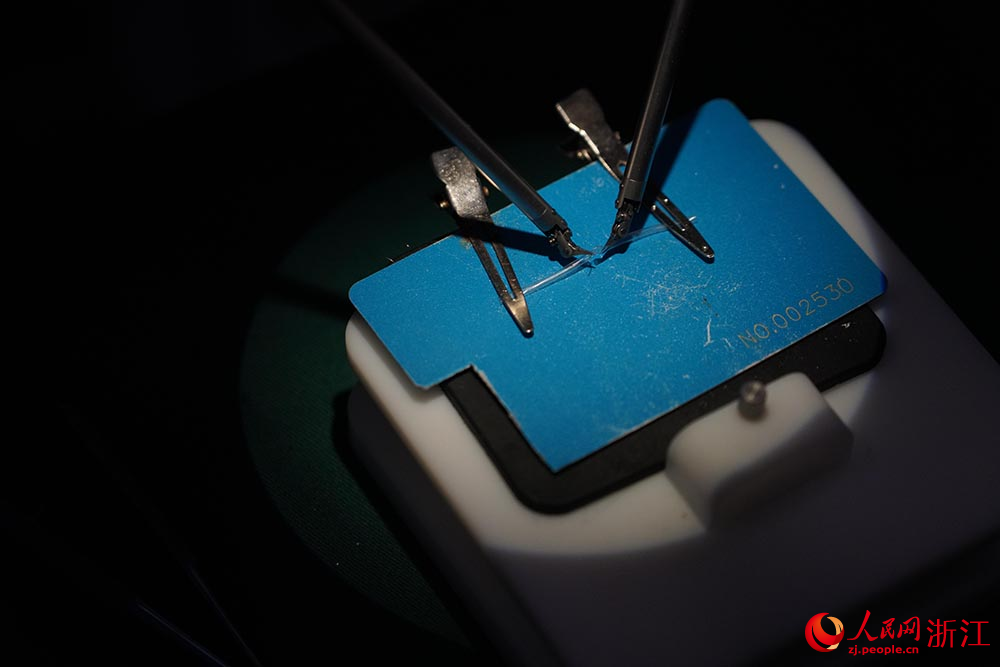 5月27日，研發人員使用顯微外科手術機器人進行仿真血管的吻合操作。人民網 章勇濤攝