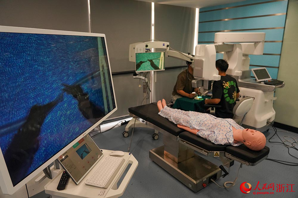 5月27日，研發人員使用顯微外科手術機器人進行仿真血管的吻合操作。人民網 章勇濤攝