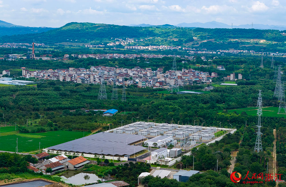 陽光下的光伏板陣列熠熠生輝，與一排排白色儲能電池整齊排列，共同構成蓄勢待發的“電力糧倉”。人民網 章勇濤攝