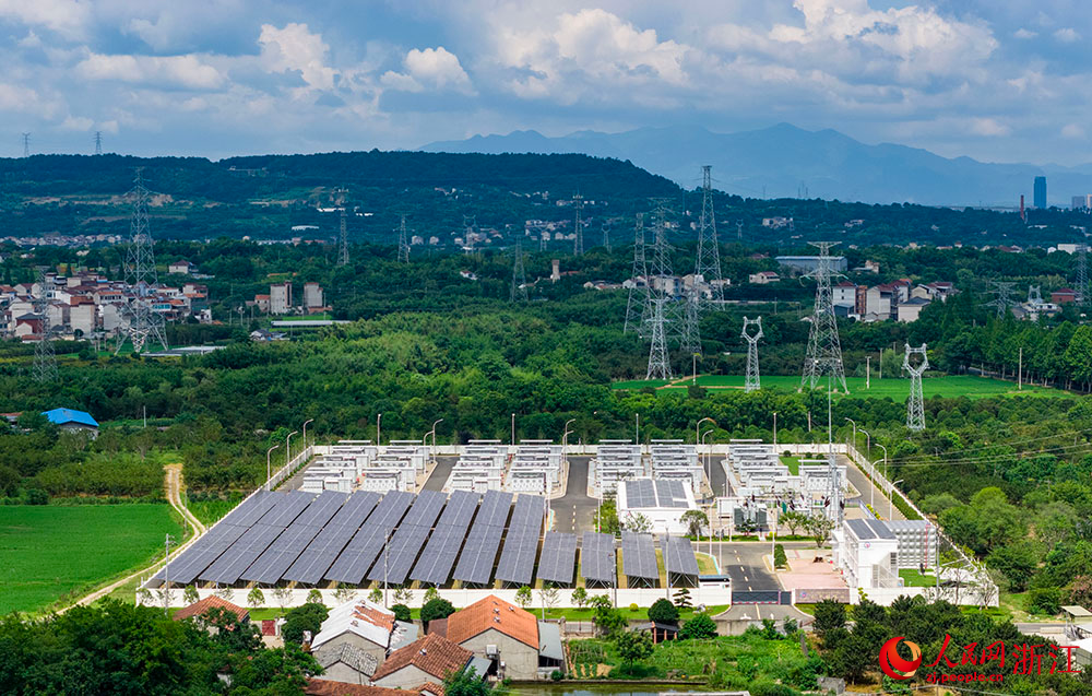 陽光下的光伏板陣列熠熠生輝，與一排排白色儲能電池整齊排列，共同構成蓄勢待發的“電力糧倉”。人民網 章勇濤攝