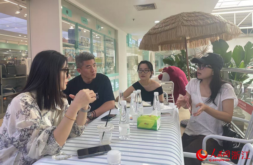 何犁紅（右一）為意大利客商介紹品牌集合店情況。人民網記者 王麗瑋攝